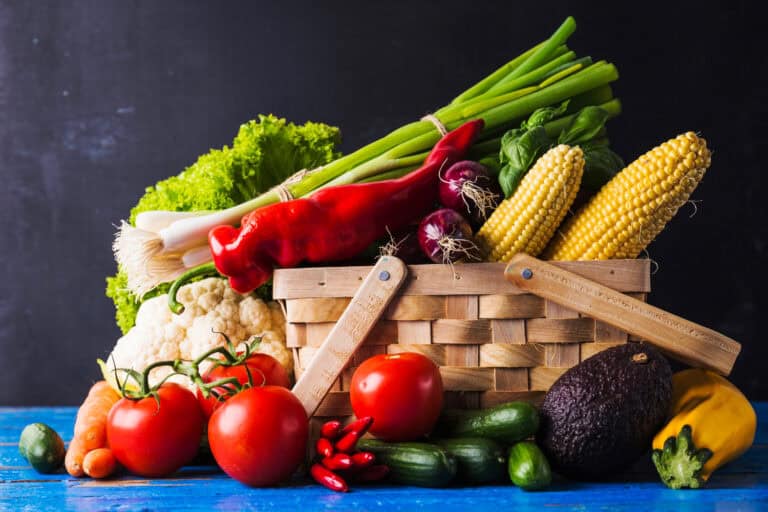 Basket overflowing with whole fruits and vegetables