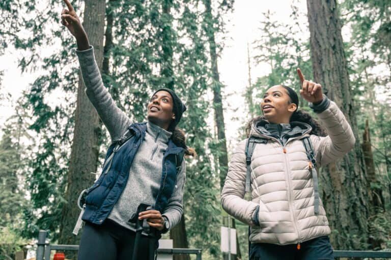 Two people walking and talking in nature, illustrating the benefits of meaningful social connection.