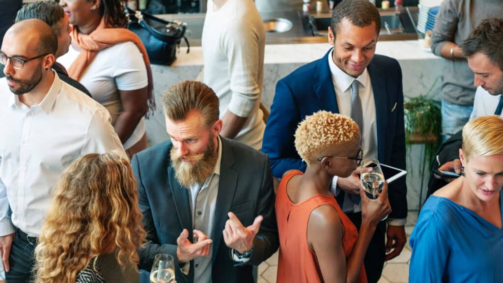 Midlife professionals at social gathering, illustrating social influences on energy and habits.